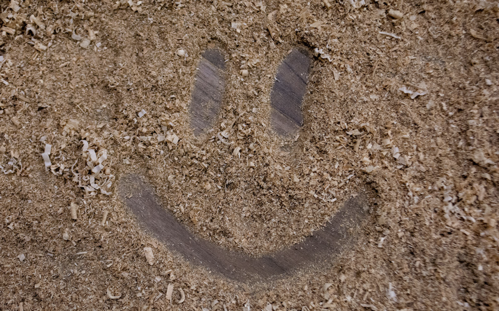 Positive mental health with smiley face drawn in sawdust